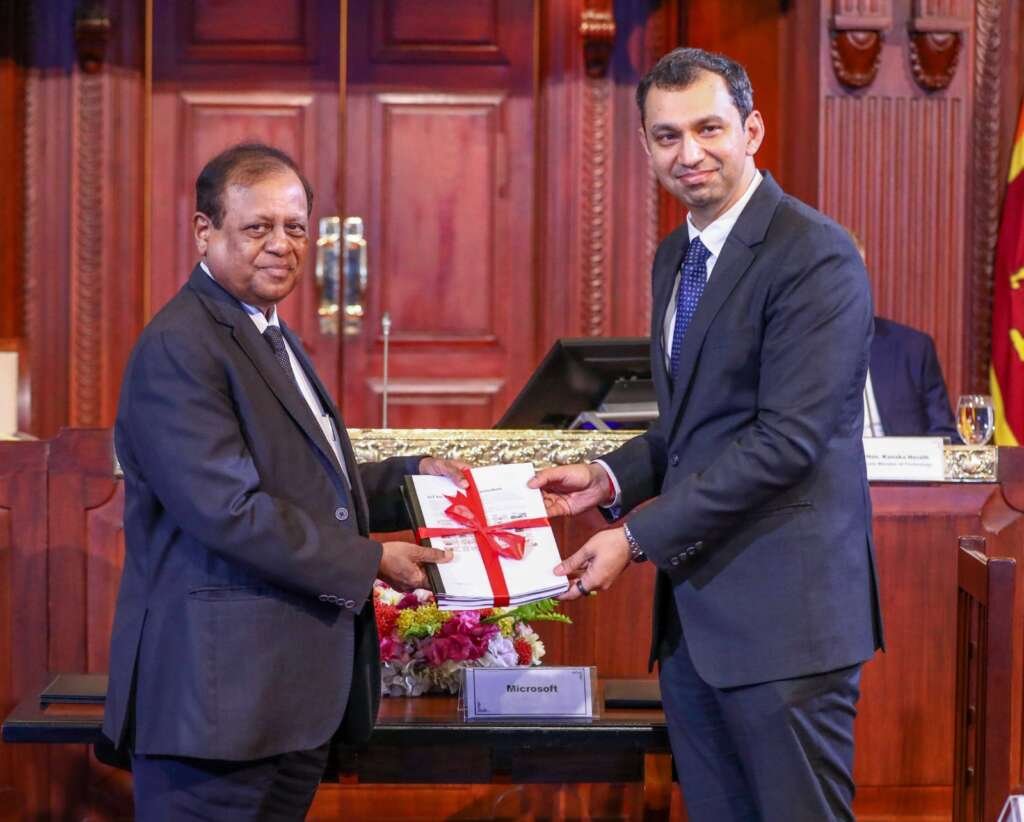 Photo Caption: Dr. Susil Premajayantha, Education Minister, and Puneet Chandok, President of Microsoft India and South Asia, exchange model books of the updated national curriculum.